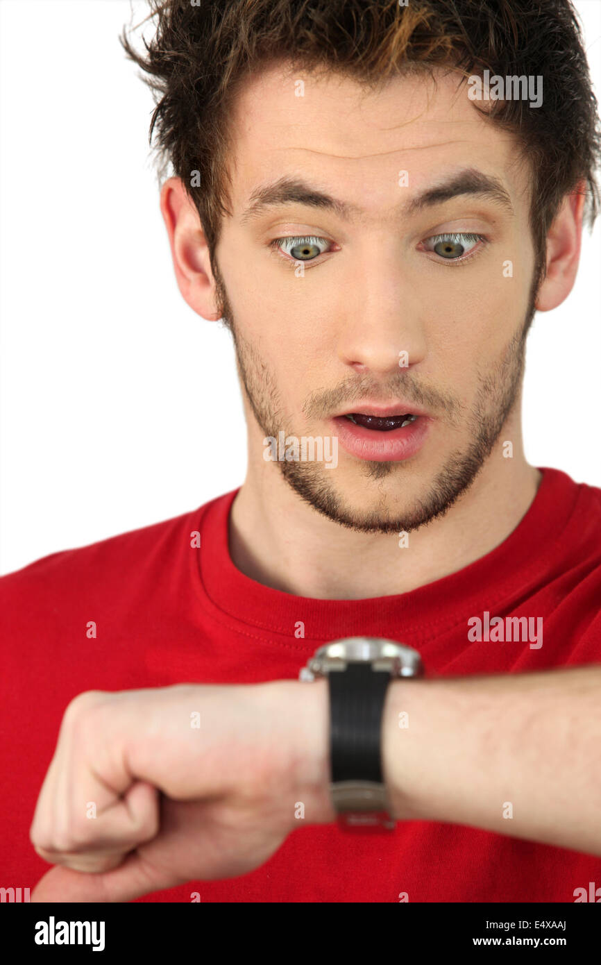 Mann unter Schock Blick auf seine Uhr Stockfoto