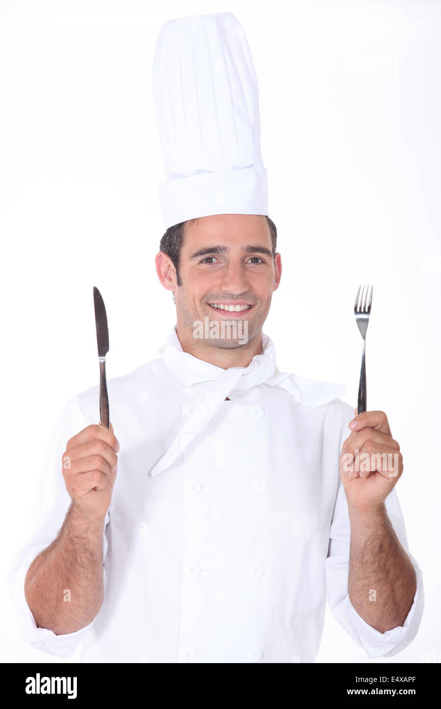 Koch in weiß mit Messer und Gabel Stockfoto