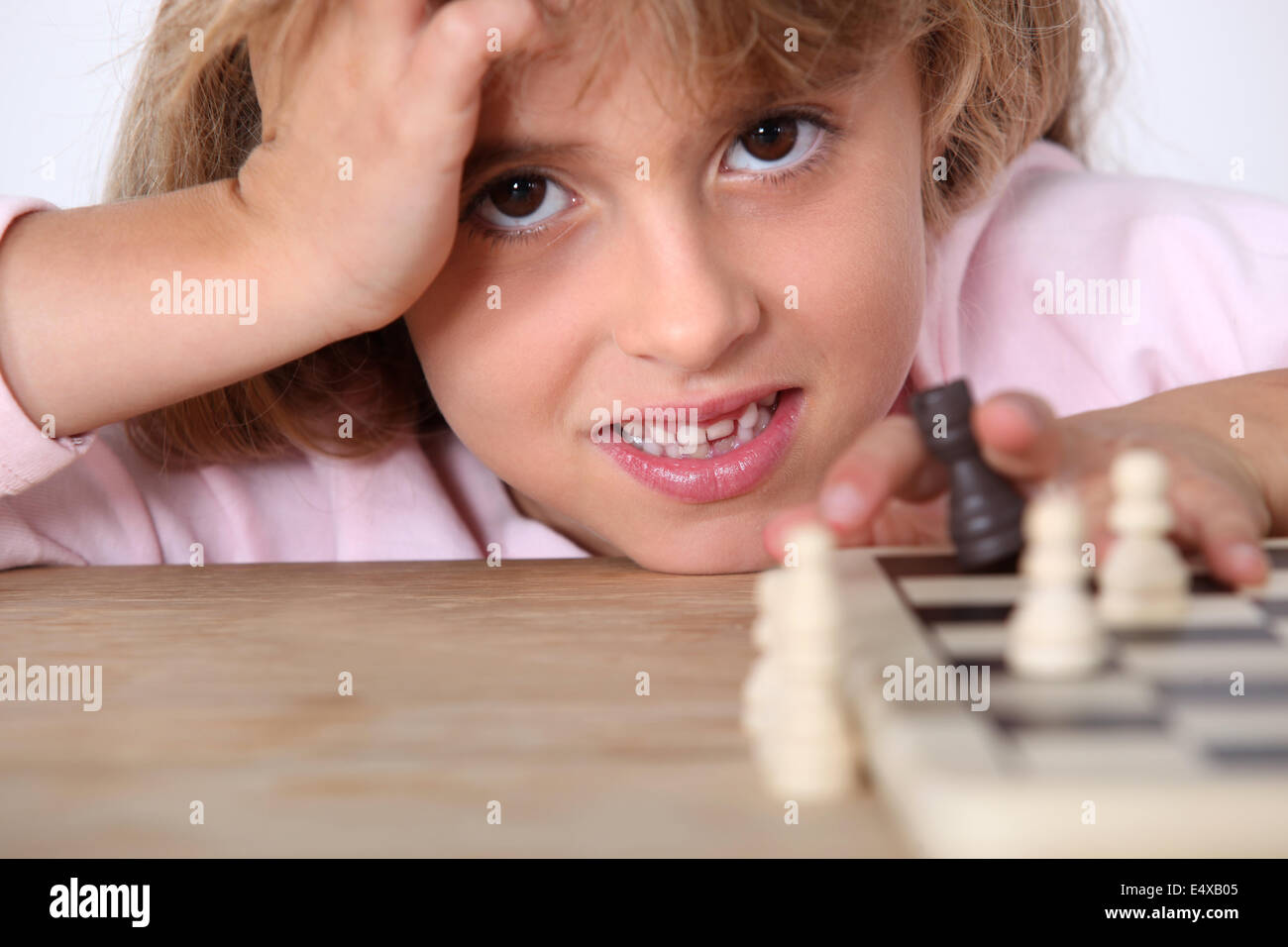 Kleines Mädchen alleine Schach spielen Stockfoto