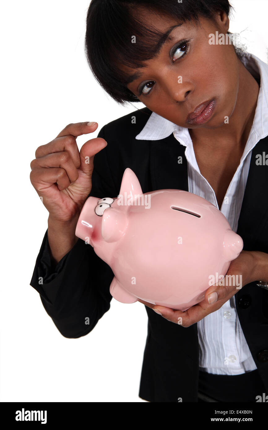 Eine Geschäftsfrau hält ein Sparschwein. Stockfoto
