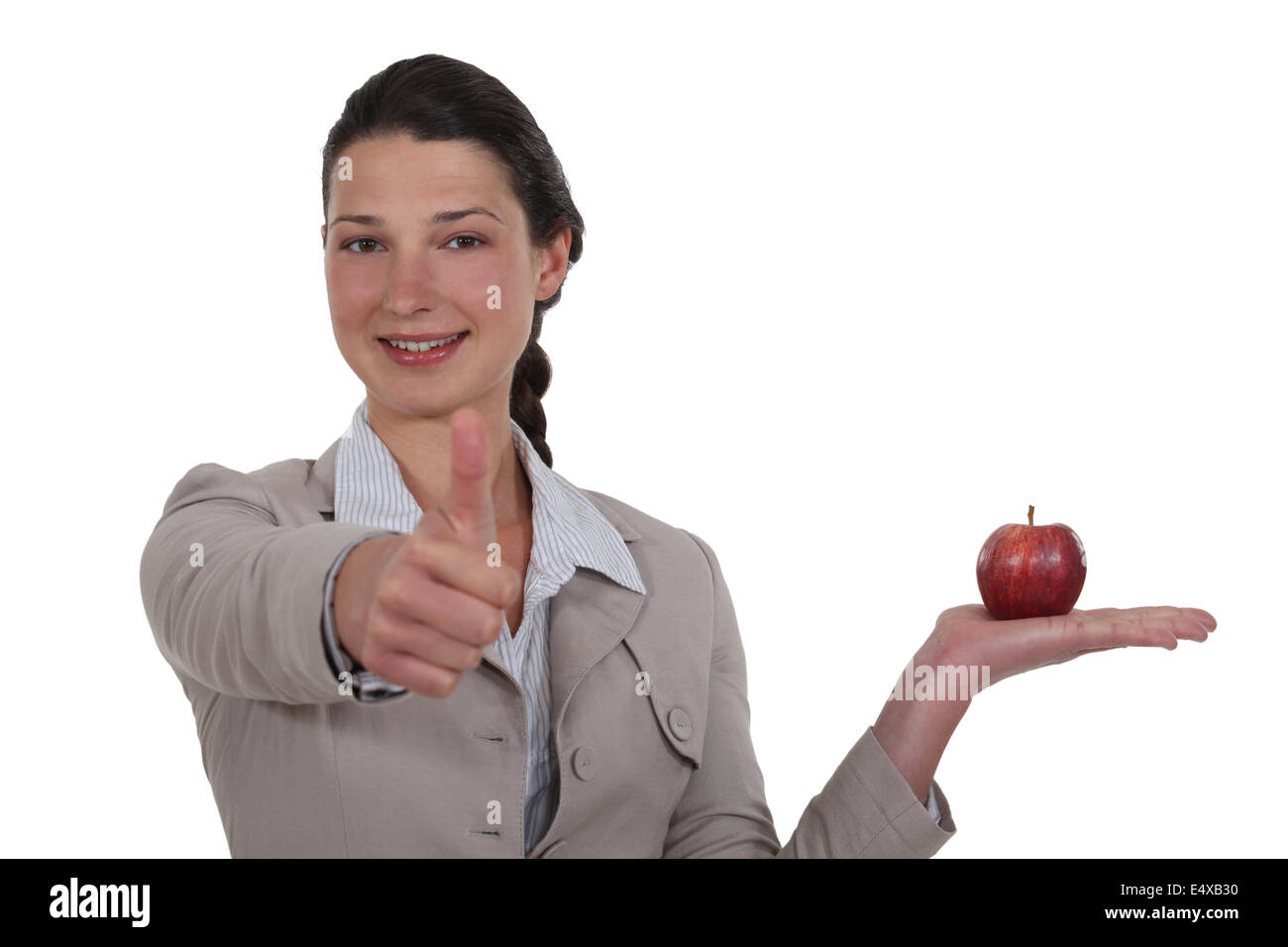 Geschäftsfrau, die Genehmigung eines Apfels Stockfoto