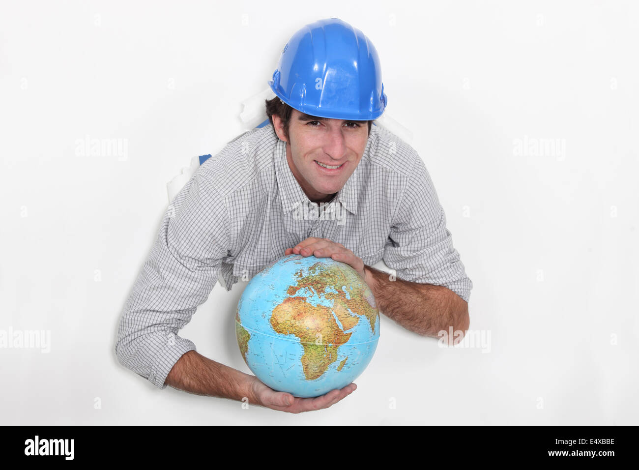 Ein Bauarbeiter, hält einen Globus. Stockfoto