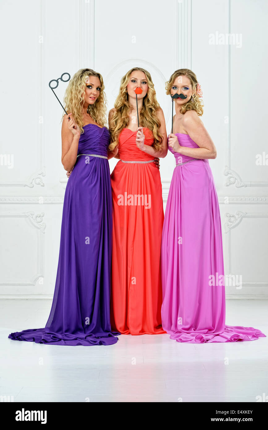 Drei Frauen im Abendkleid mit Masken. Stockfoto