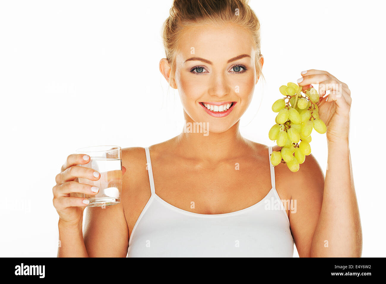 Schöne Frau mit Trauben und Wasser Stockfoto