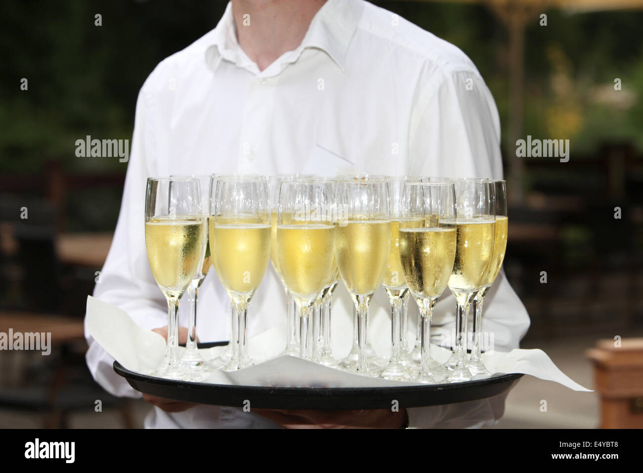 Der Kellner mit einem Tablett mit Champagner-Flöten Stockfoto