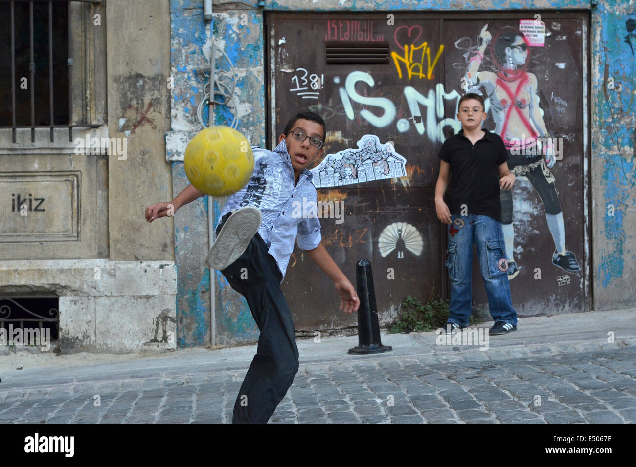 Zwei türkische Kinder spielen Fußball in einer ruhigen Straße in Beyoglu. Stockfoto