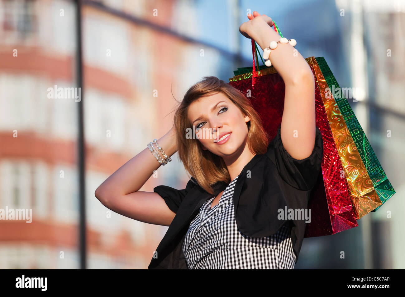 Glückliche junge Frau mit Einkaufstüten Stockfoto