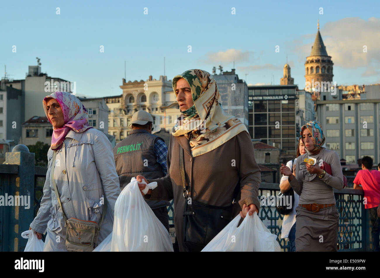 Türkische Frauen das tragen islamischer Kopftücher Fuß auf der Galata-Brücke im Zentrum von Istanbul. Historische Galata-Turm kann in gesehen werden Stockfoto