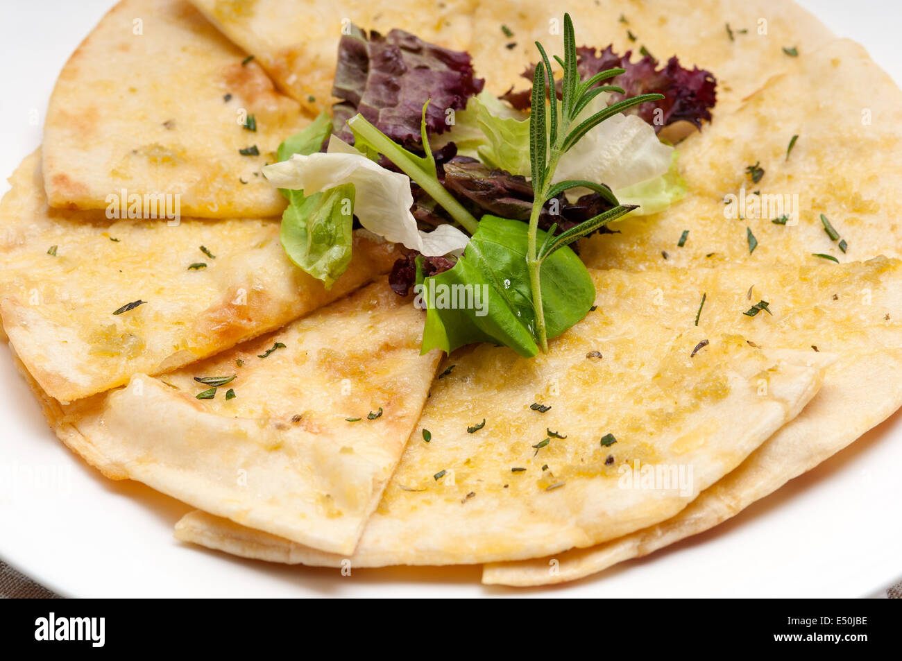 Knoblauch-Pita-Brot-Pizza mit Salat an der Spitze Stockfoto