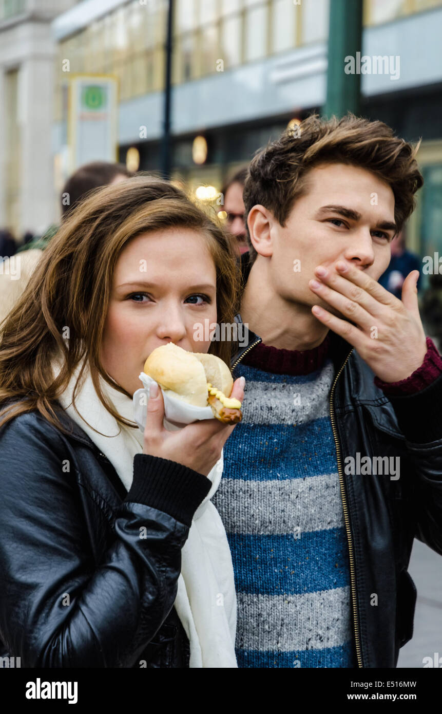 Woman Eating Hotdog beim Mann Reinigung Mund Stockfoto