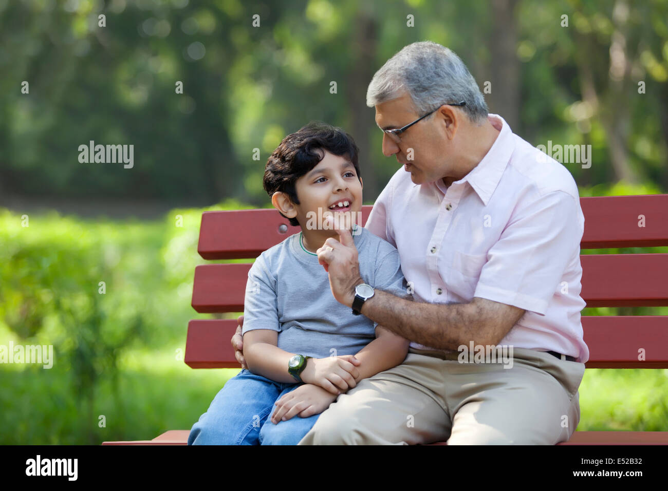 Großvater und Enkel sitzen in einem park Stockfoto