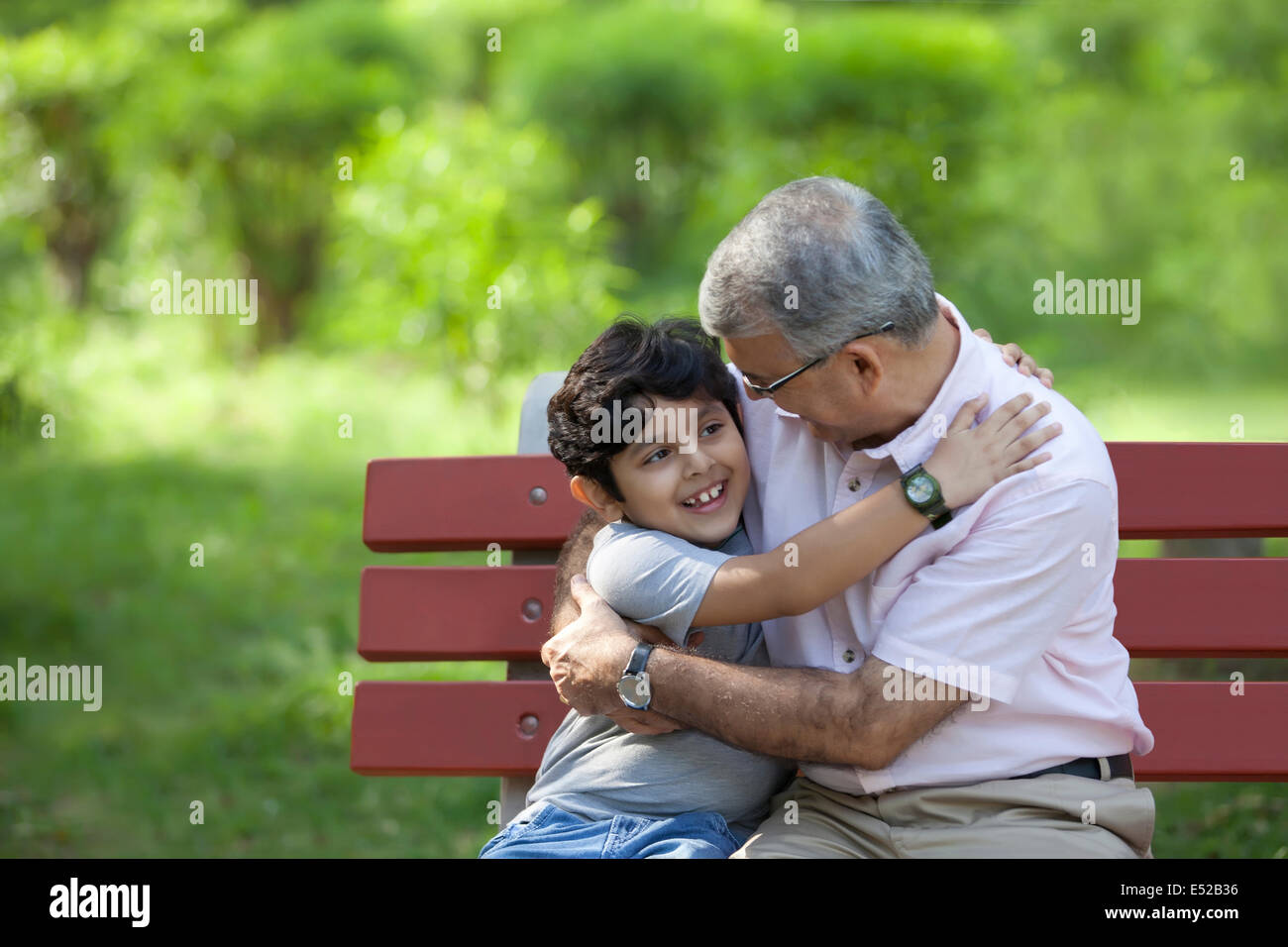 Großvater und Enkel, die in einem Park umarmt Stockfoto