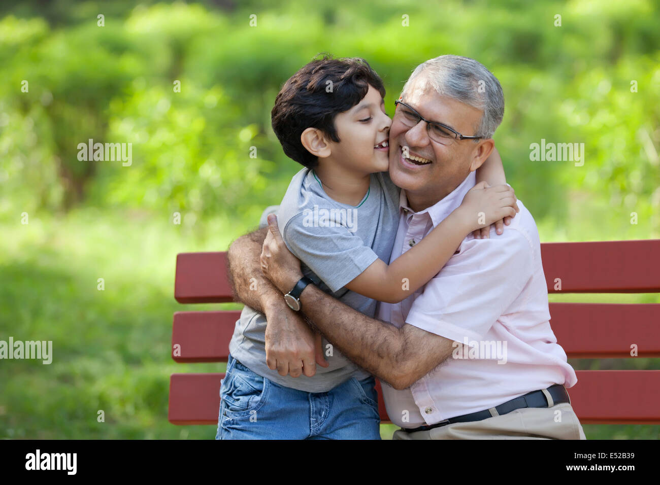 Großvater und Enkel, die in einem Park umarmt Stockfoto