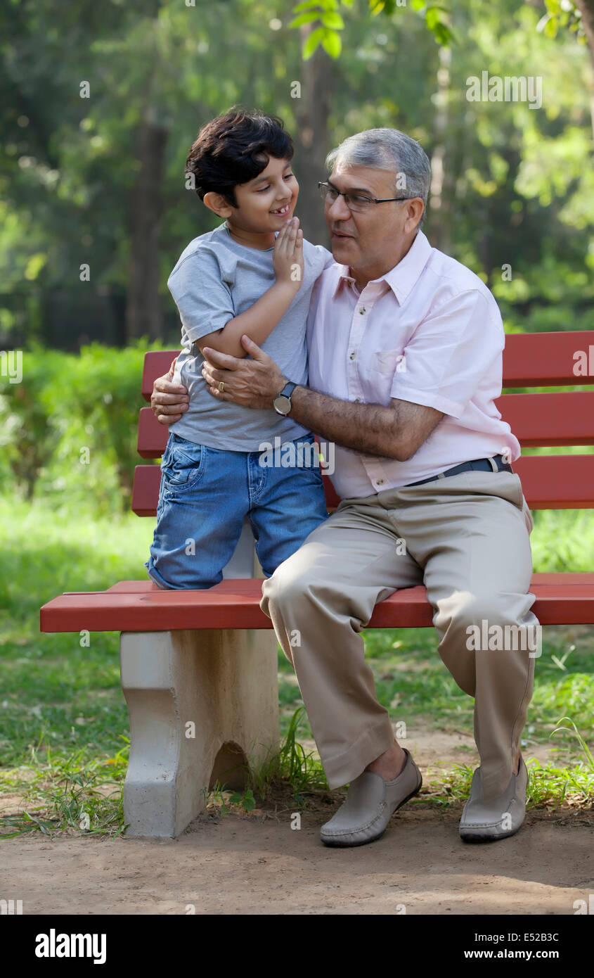 Großvater Lächeln nach dem Enkel Geheimnis anhören Stockfoto