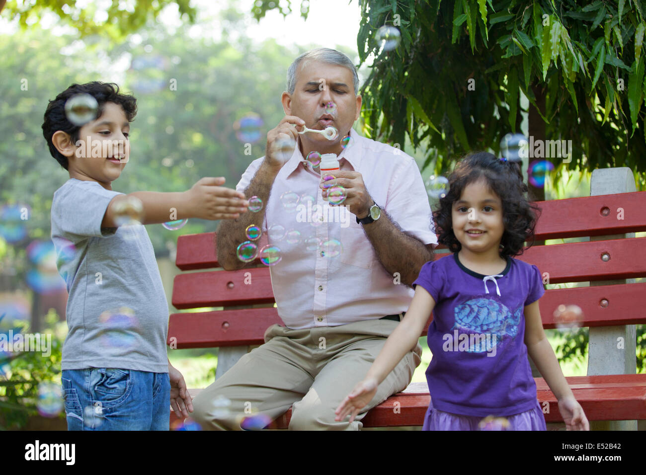 Großvater Seifenblasen mit Enkelkindern im park Stockfoto
