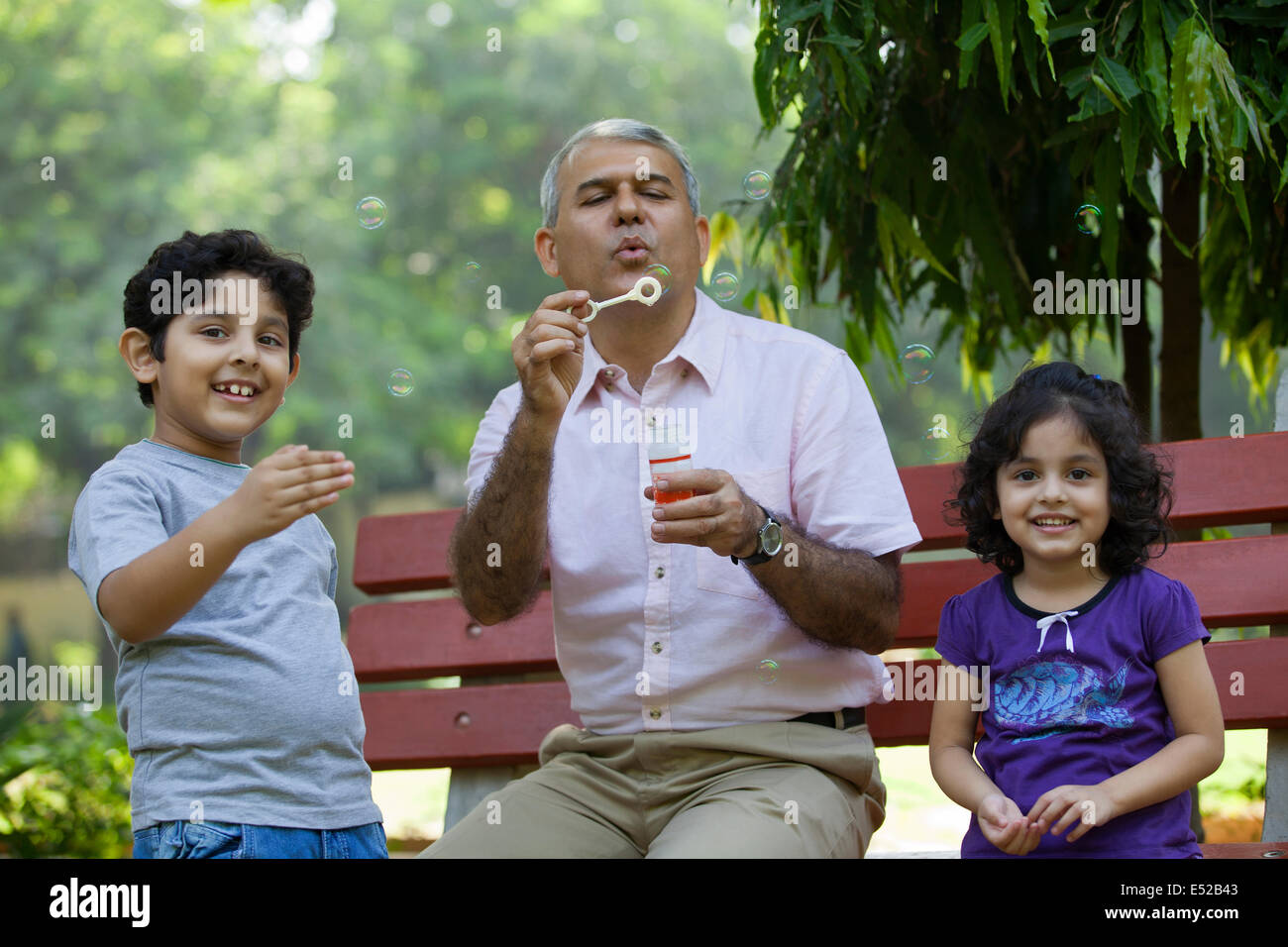 Großvater Seifenblasen mit Enkelkindern im park Stockfoto