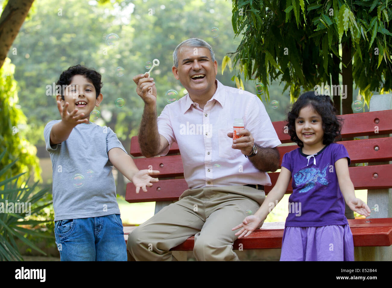 Porträt von Großvater mit Enkel Seifenblasen im park Stockfoto
