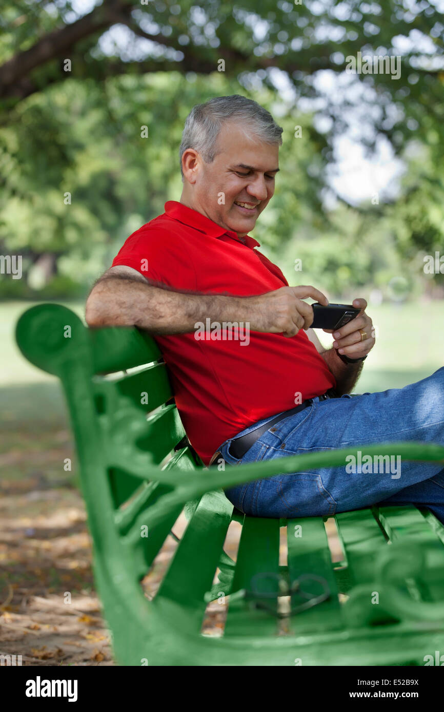 Ältere Mann liest eine Sms auf dem Handy Stockfoto