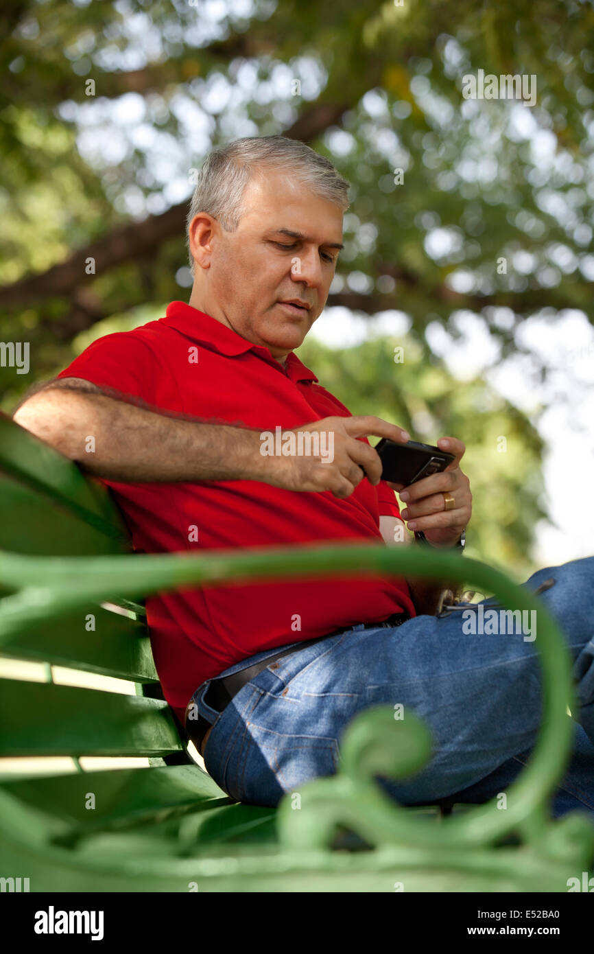 Ältere Mann liest eine Sms auf dem Handy Stockfoto