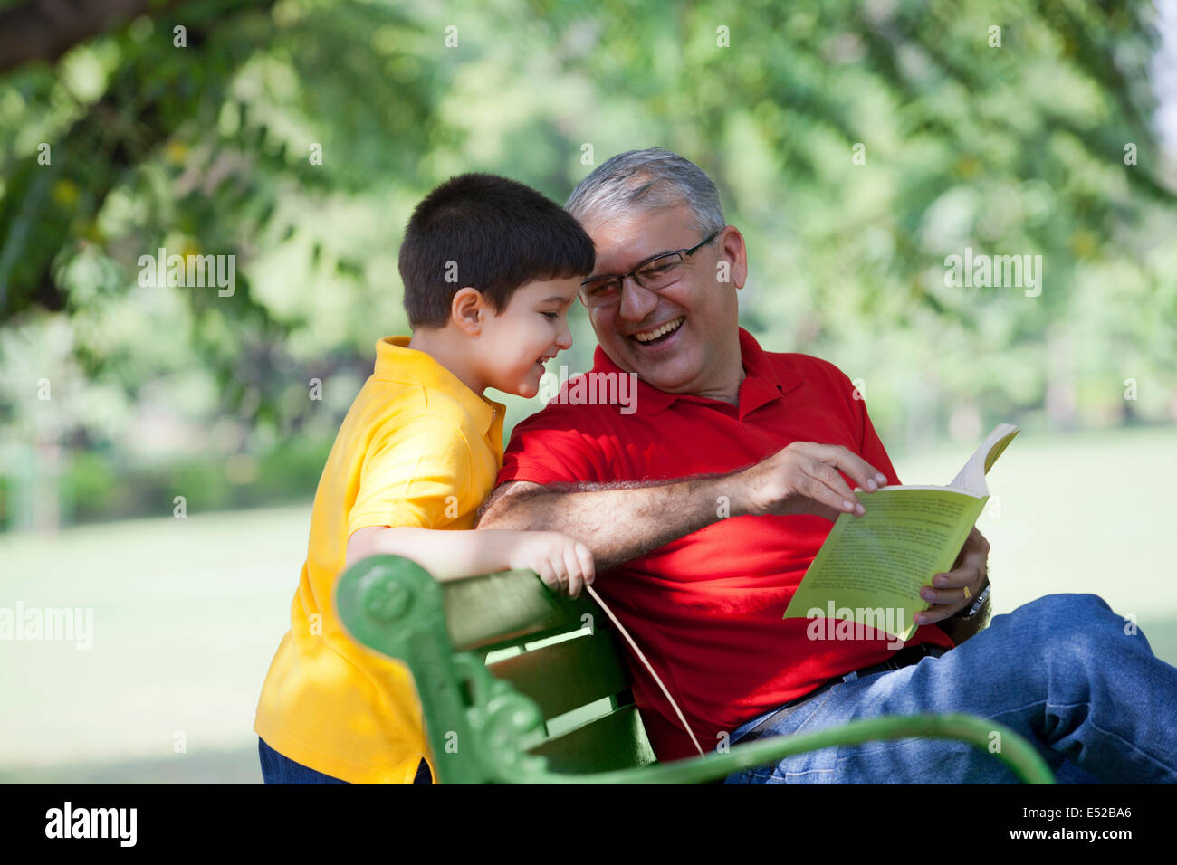 Großvater mit Buch, Enkel Stockfoto