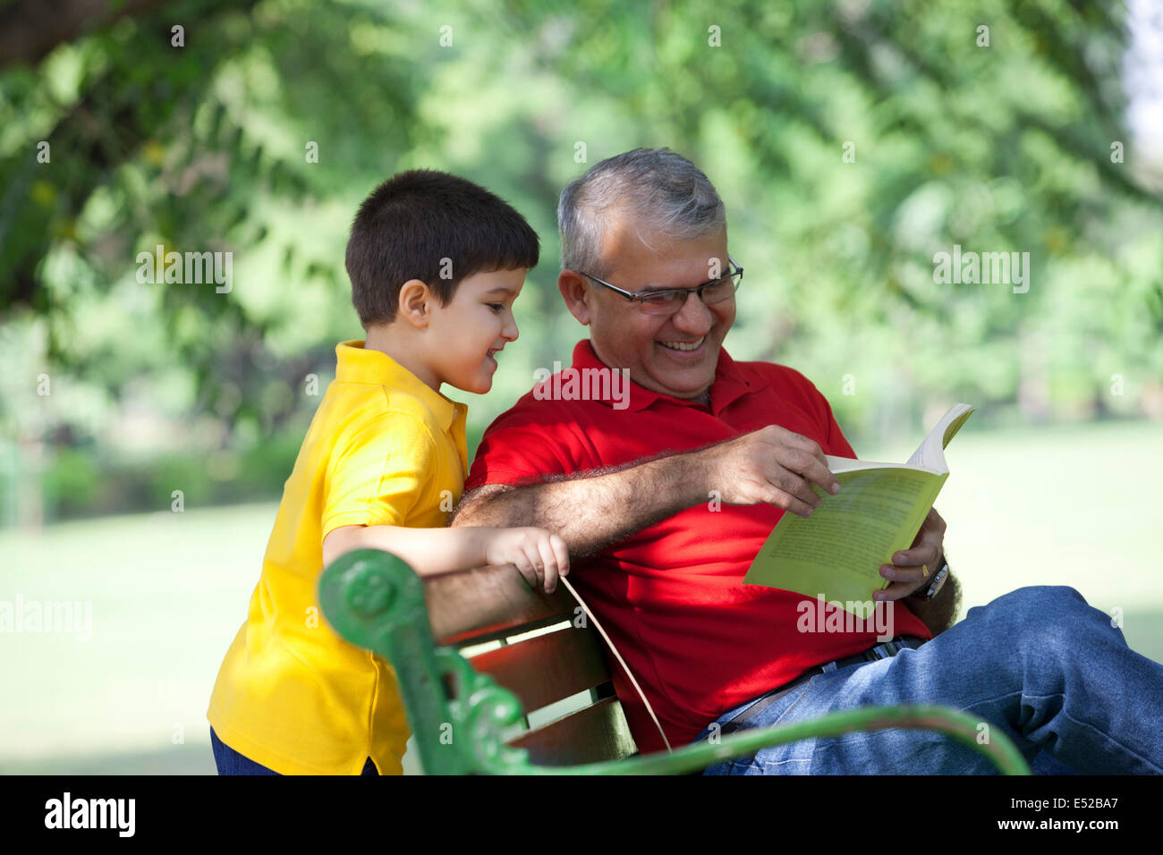 Großvater und Enkel, die ein Buch suchen Stockfoto