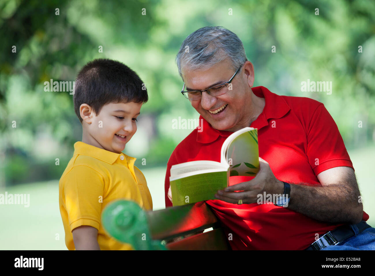 Großvater mit Buch, Enkel Stockfoto