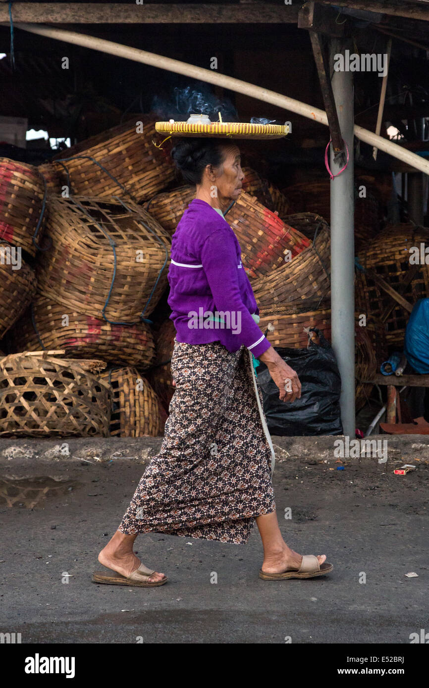 Bali, Indonesien.  Frau mit Schale auf Kopf, Weihrauch verbrennen.  Jimbaran Fischmarkt. Stockfoto