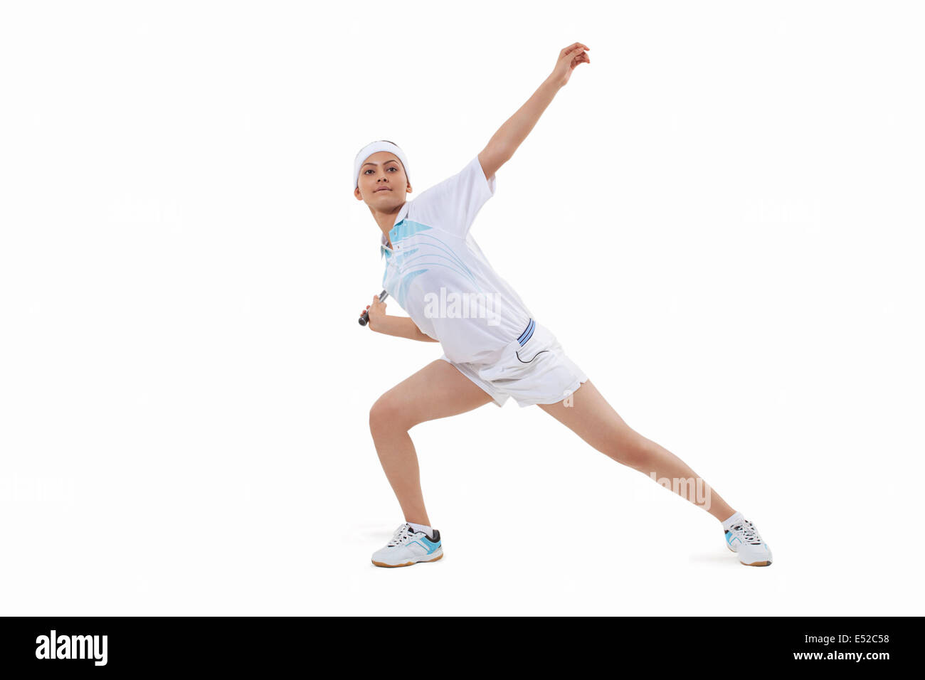 Junge Frau in Sportkleidung spielen Badminton isoliert auf weißem Hintergrund Stockfoto