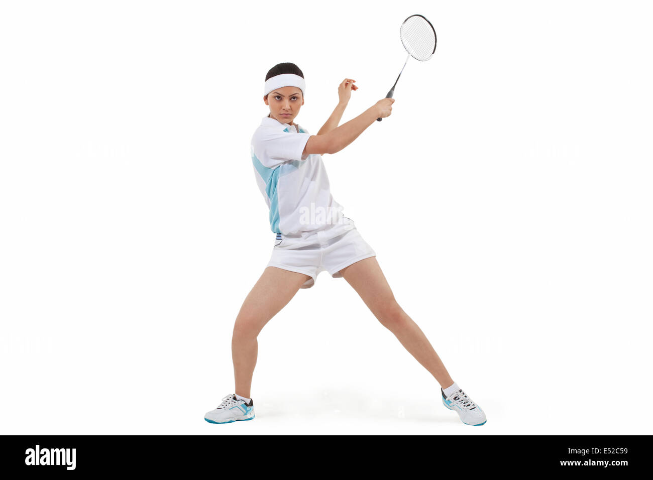 Junge Frau im Sport tragen spielen Badminton vor weißem Hintergrund Stockfoto