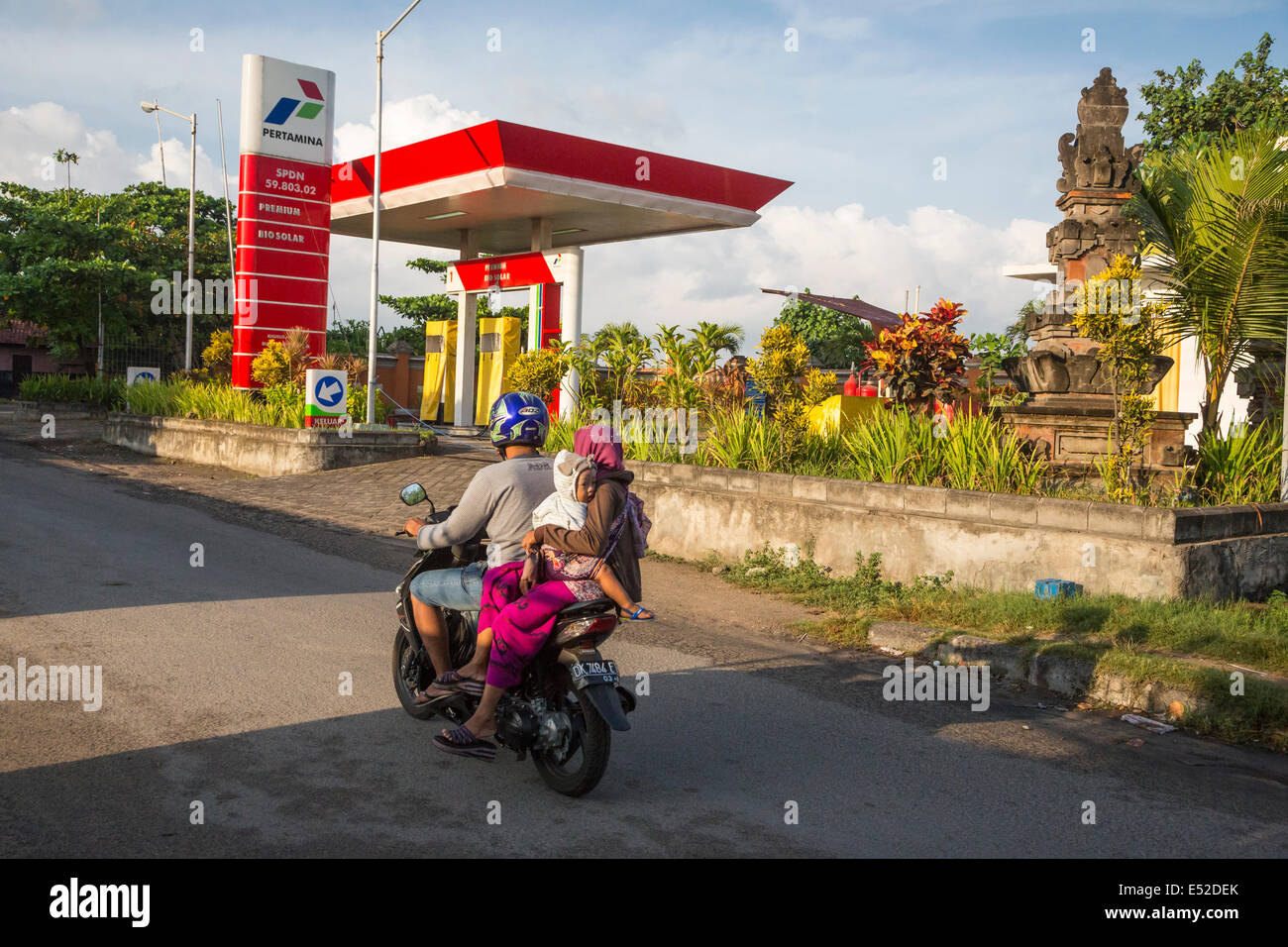 Bali, Indonesien.  Sicherheit im Straßenverkehr.  Mutter und Tochter am Heck von Motorrad, keine Helme. Stockfoto