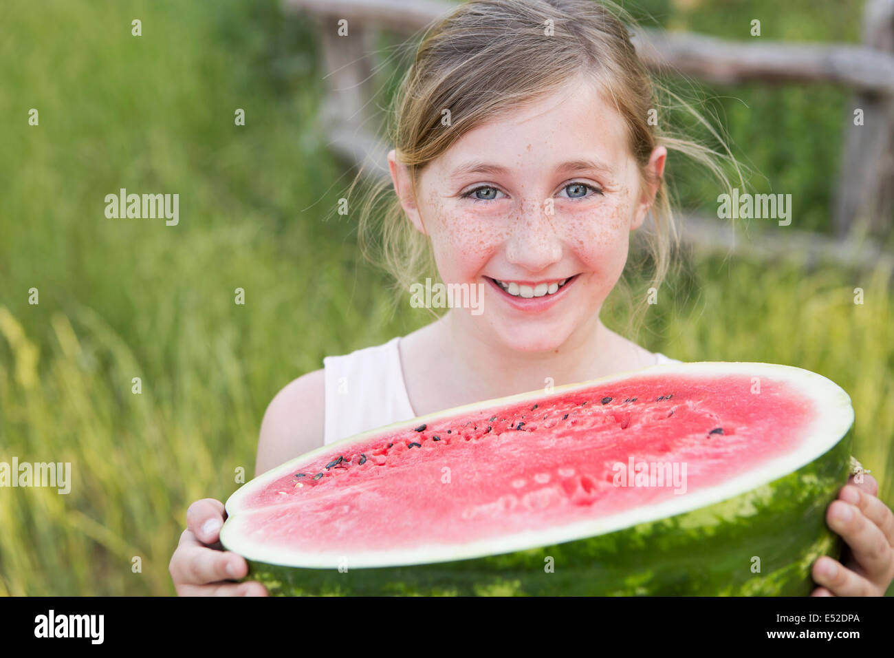 Ein Kind hält eine halbe Melone ein frisches Wasser. Stockfoto