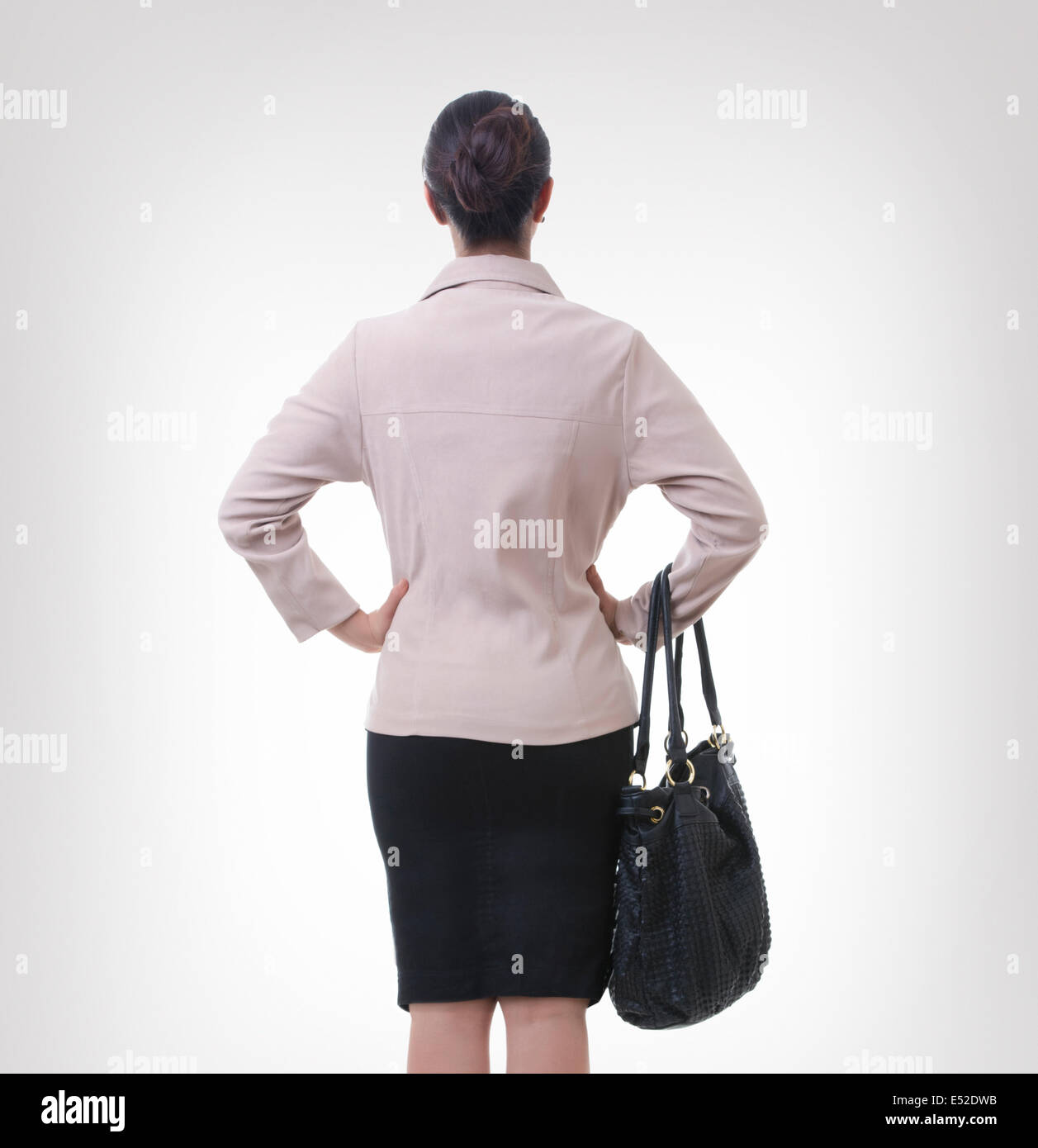 Rückansicht des gut gekleideten Geschäftsfrau auf grauem Hintergrund Stockfoto