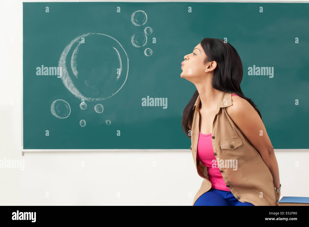 Weibliche College-Studentin bläst Stockfoto