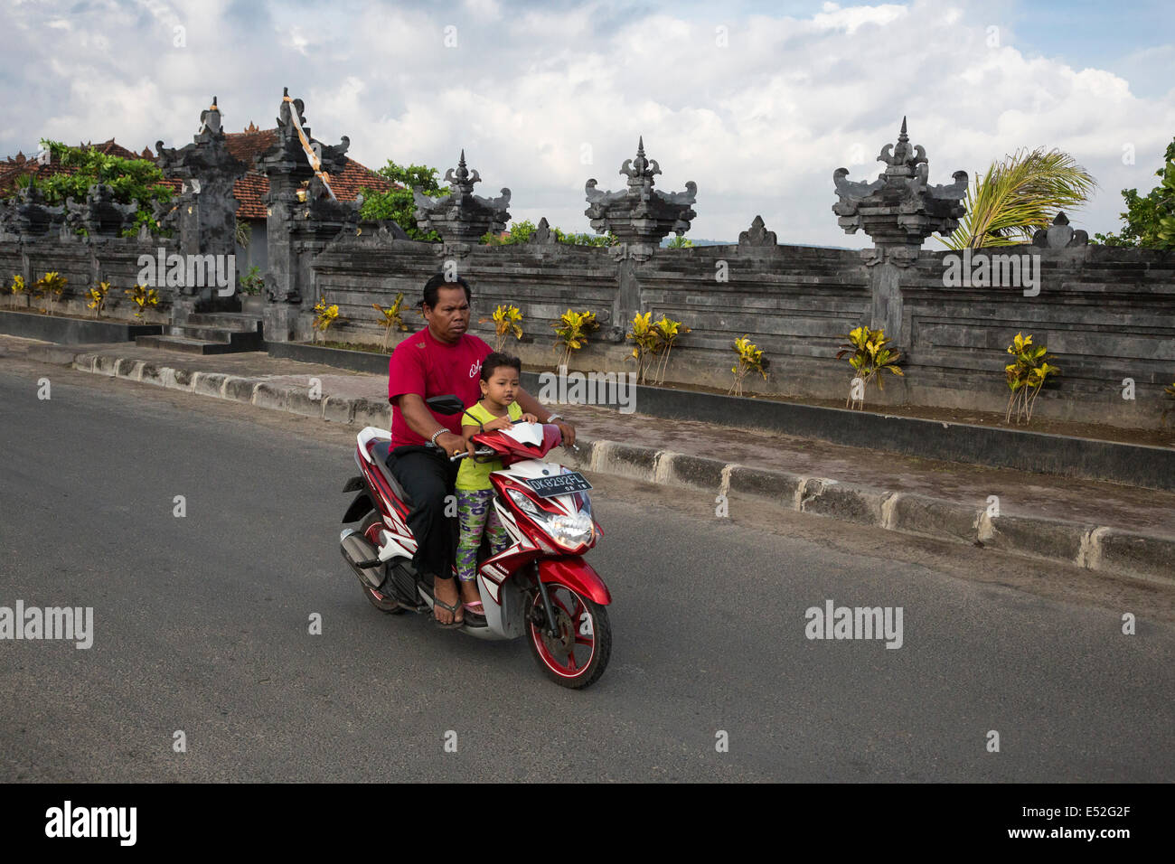 Bali, Indonesien.  Sicherheit im Straßenverkehr.  Vater und Tochter auf dem Motorrad, keine Helme. Stockfoto