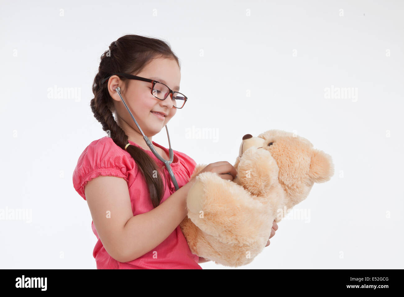 Kleine Mädchen spielen Arzt mit einem Teddy-Bären Stockfoto