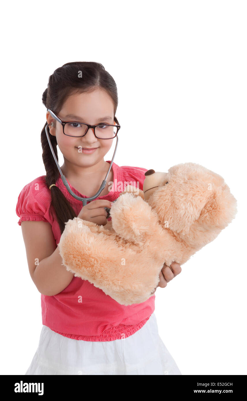 Porträt von kleinen Mädchen spielen Arzt mit Teddybär Stockfoto