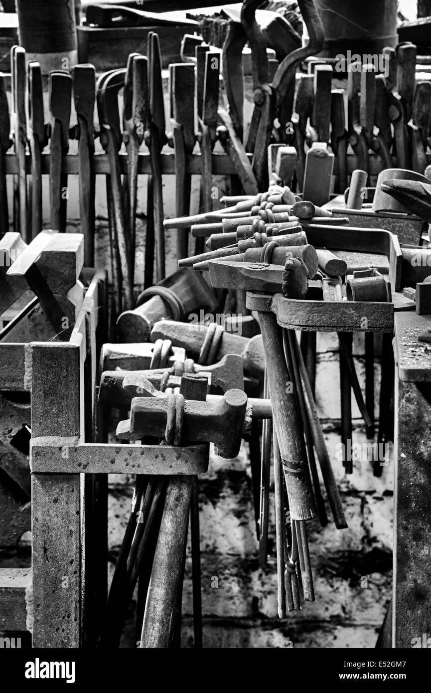 Schmiede-Werkzeuge in einer Werkstatt. Schüren Sie Bruerne, Northamptonshire, England. Monochrom Stockfoto