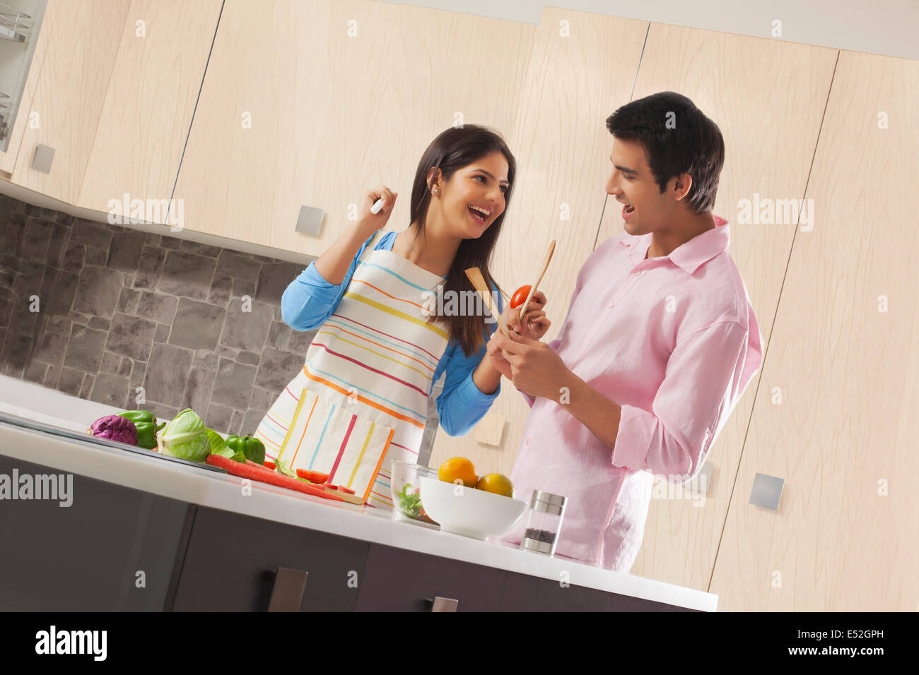 Verspieltes paar Vorbereitung gesunden Salat in Küche Stockfoto