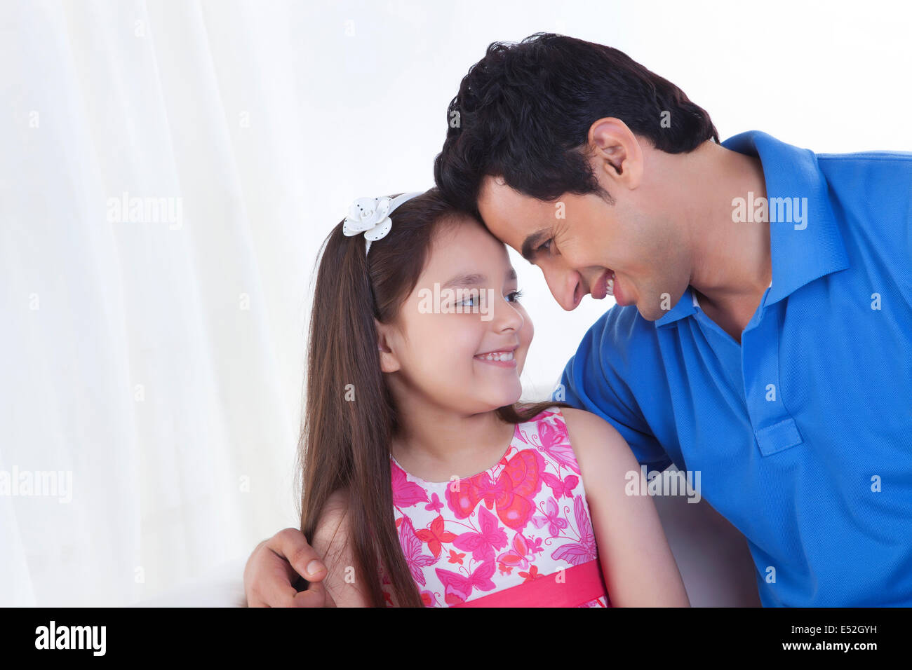 Glücklicher Vater und Tochter mit Kopf an Kopf zu Hause Stockfoto
