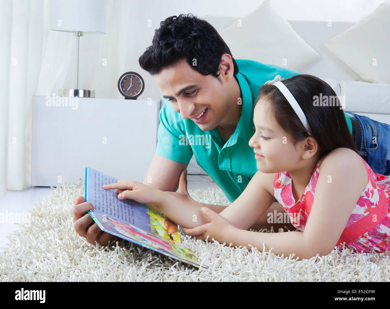 Vater und Tochter Geschichte Buch liegend auf Teppich zu Hause Stockfoto