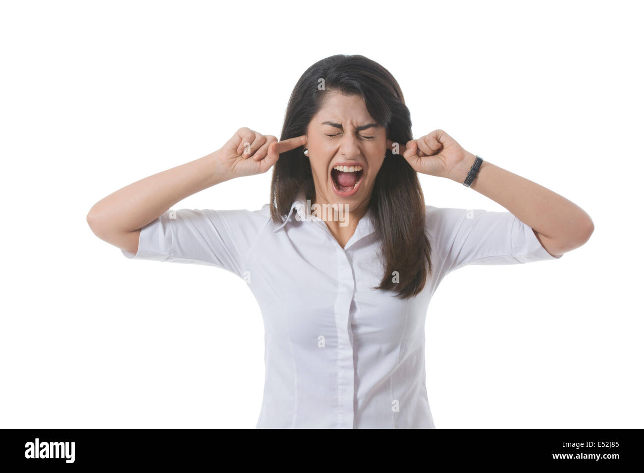 Frustriert Geschäftsfrau mit Finger in Ohren schreien auf weißem Hintergrund Stockfoto