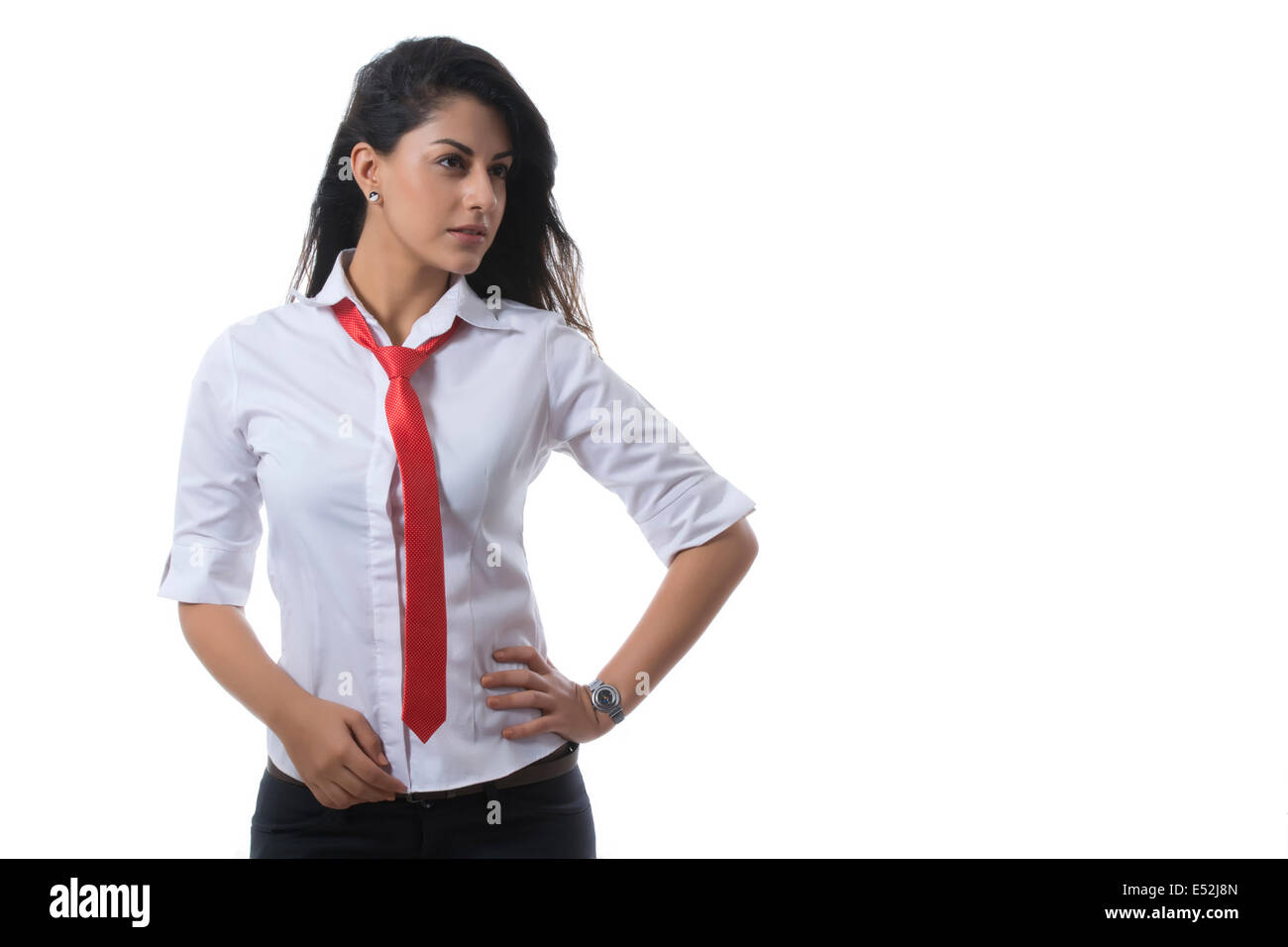 Zuversichtlich modische Geschäftsfrau mit Hand auf Hüfte vor weißem Hintergrund Stockfoto