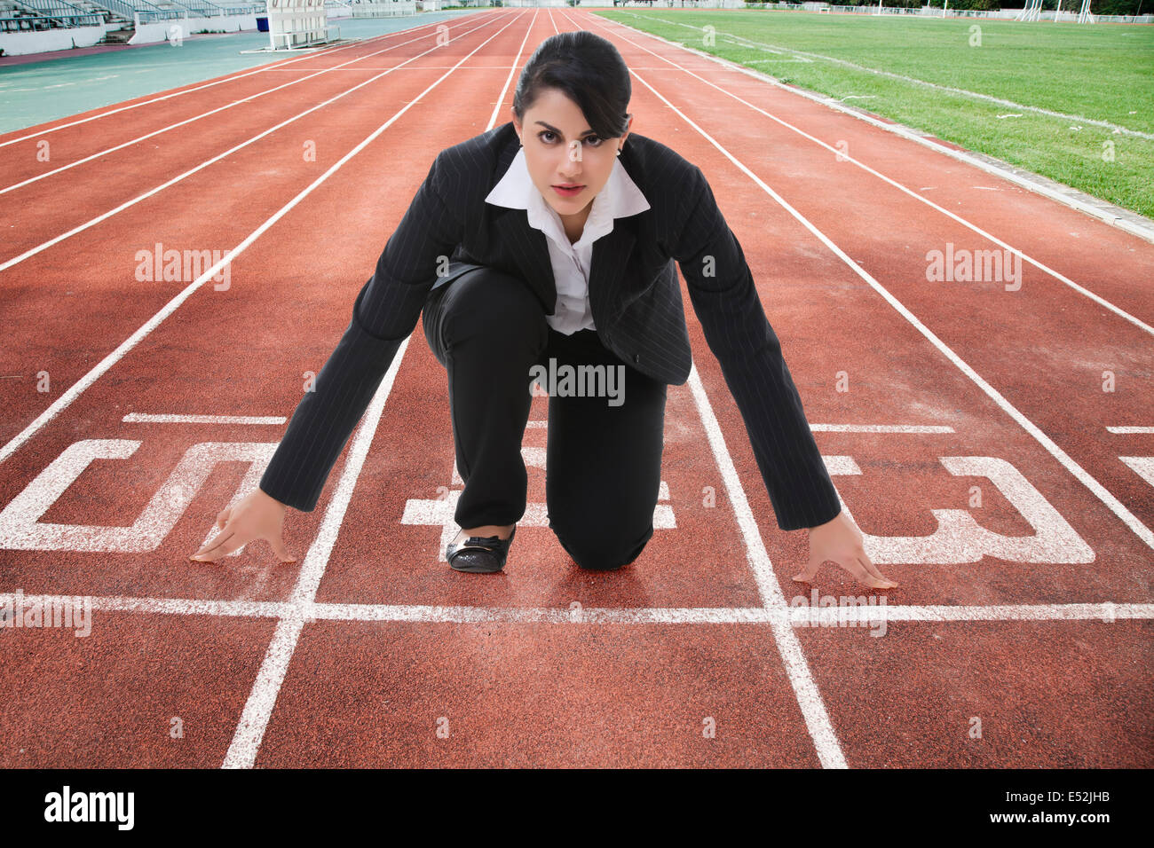 Porträt von zuversichtlich Geschäftsfrau an Startlinie auf Rennen verfolgen Stockfoto