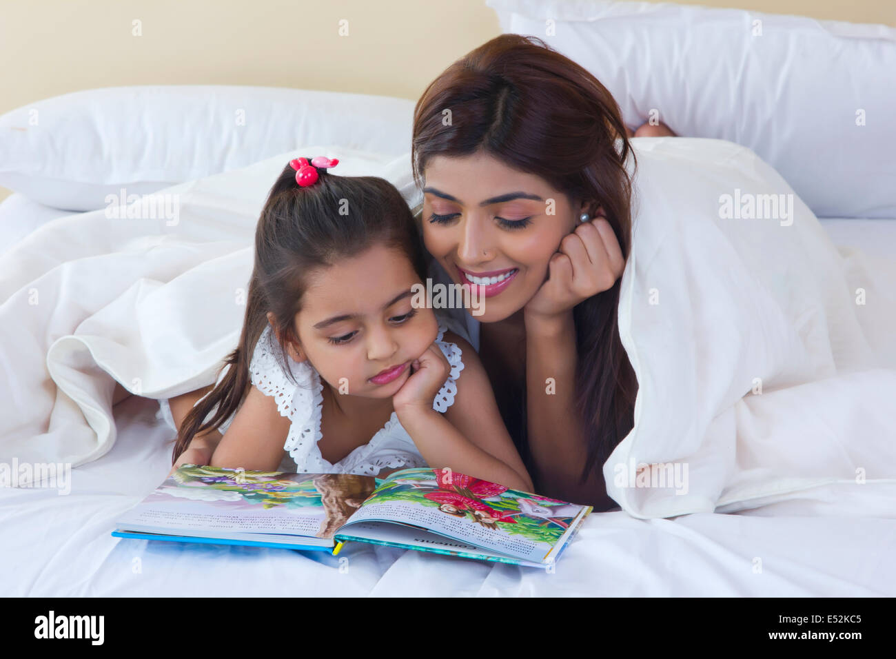 Mutter und Tochter-Lesung-Bilderbuch im Bett Stockfoto