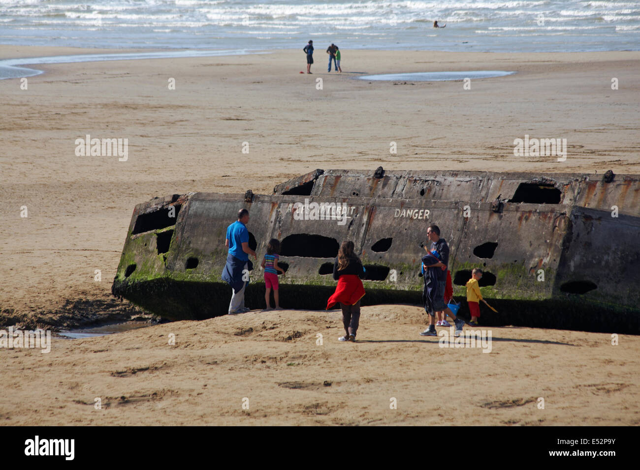 Besucher erkunden die Reste der Mulberry Hafen am Strand von Arromanches Normandie Frankreich im Juli Stockfoto