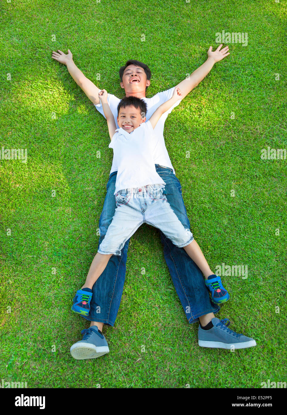 glücklicher Vater und Sohn zusammen auf einer Wiese liegend Stockfoto