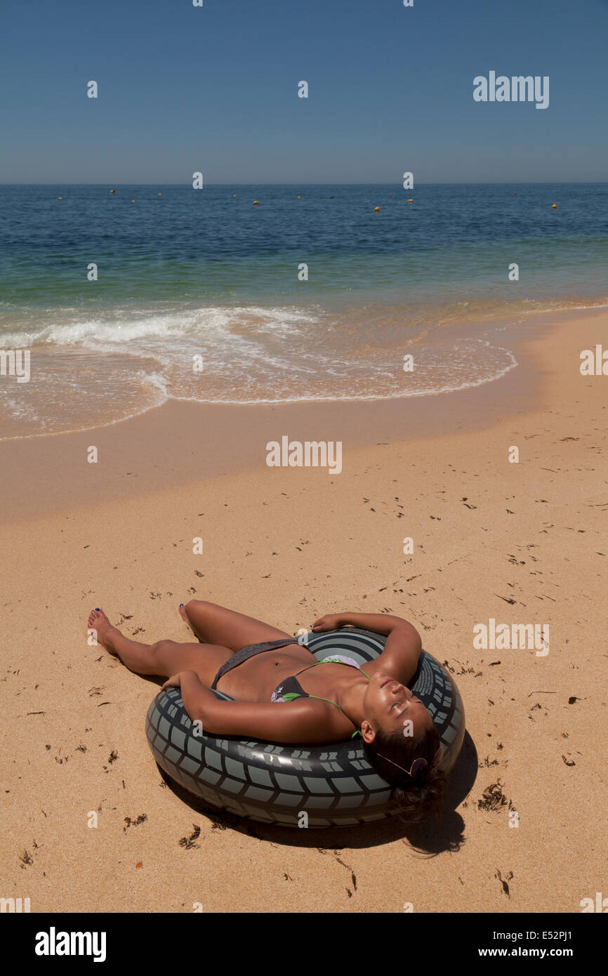 Junge Frau Sonnenbaden und immer eine Sonnencreme am Strand, Algarve Portugal Europa Stockfoto