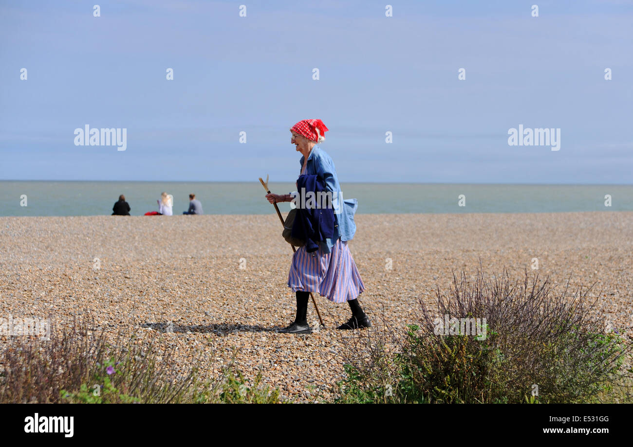 Aldeburgh Suffolk UK - Blick auf die Küstenstadt Aldeburgh Lady, die mit einem Stock am Strand entlang geht Stockfoto