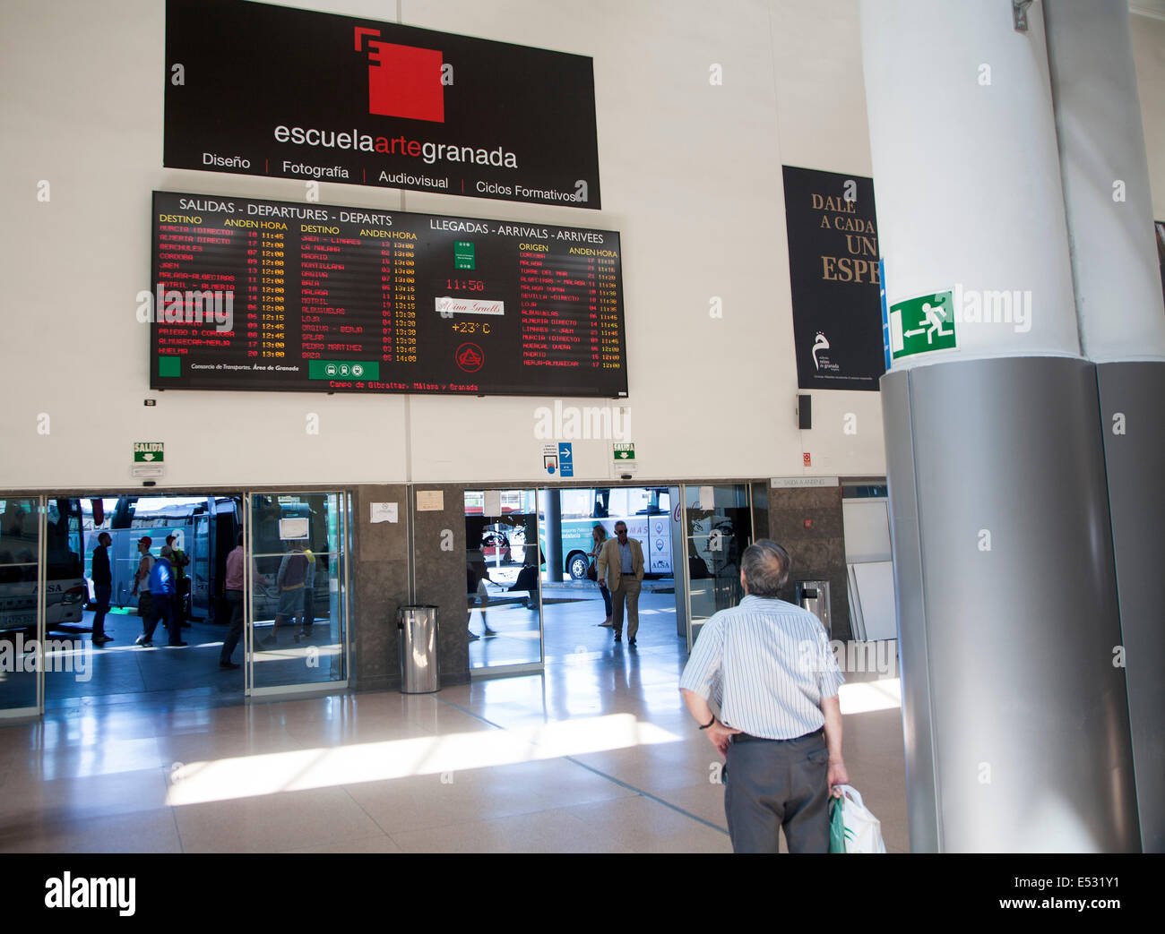 Mann sucht bei Infotafel über Bus an- und Abreise, Busbahnhof von Granada, Spanien Stockfoto