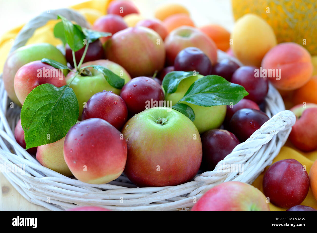 Frisches Obst mit Blättern in Korb. Stockfoto